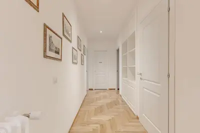 a hallway with white walls and a wooden floor at Roma Vatican City in Rome