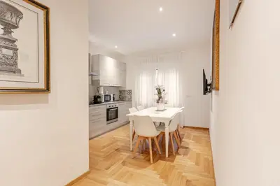 a white kitchen with a white table and chairs at Roma Vatican City in Rome