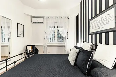 a bedroom with a black and white striped wall at Caracalla garden House in Rome