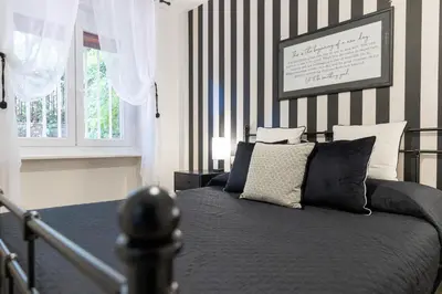 a bedroom with a bed with black and white stripes at Caracalla garden House in Rome