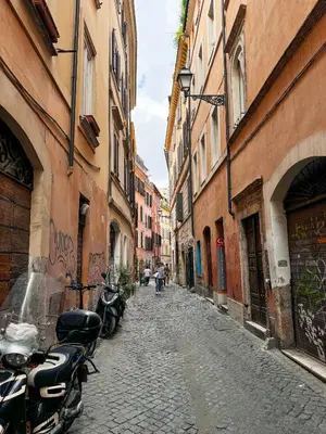 an alley with motorcycles parked on a cobblestone street at Rome Center Apartment Campo De' Fiori in Rome