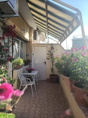 a patio with a table and chairs and potted plants at Le Buganville in Rome
