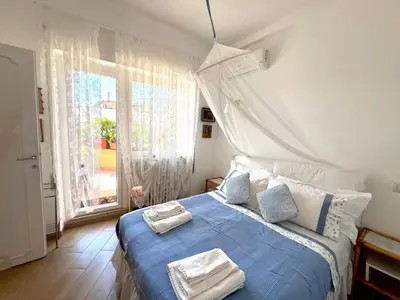 a bedroom with a blue bed with towels on it at Le Buganville in Rome