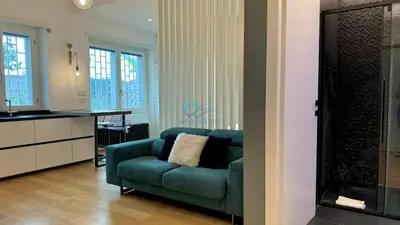 a living room with a green couch and a kitchen at Chic Studio in piazza Bologna in Rome