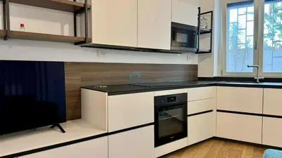 a kitchen with white cabinets and a black stove top oven at Chic Studio in piazza Bologna in Rome