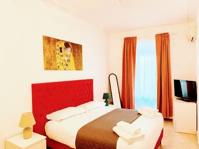 a bedroom with a red bed and a television at colosseobb in Rome