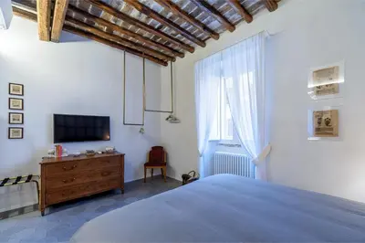 a bedroom with a bed and a tv and a window at Trastevere Luxury, ampia e confortevole location sospesa tra design e storia in Rome