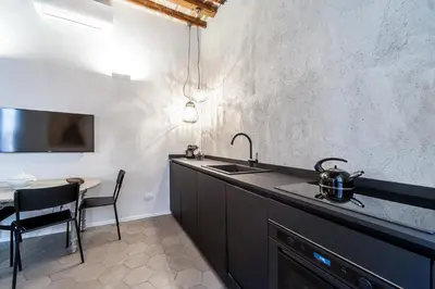 a kitchen with a sink and a dining table at Trastevere Luxury, ampia e confortevole location sospesa tra design e storia in Rome