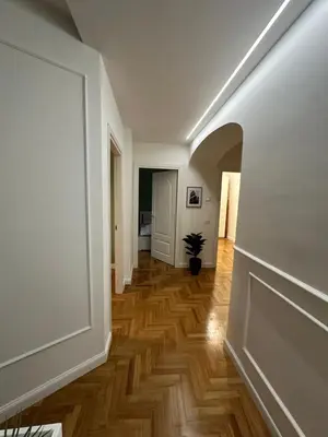 a hallway with white walls and wooden floors at Luxury Apartment Via Veneto in Rome