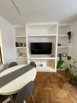 a living room with a white table and a tv at Luxury Apartment Via Veneto in Rome