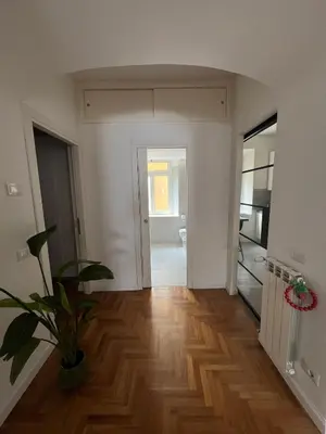 an empty living room with a potted plant on a wooden floor at Luxury Apartment Via Veneto in Rome