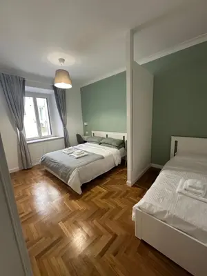 a bedroom with two beds and a large window at Luxury Apartment Via Veneto in Rome