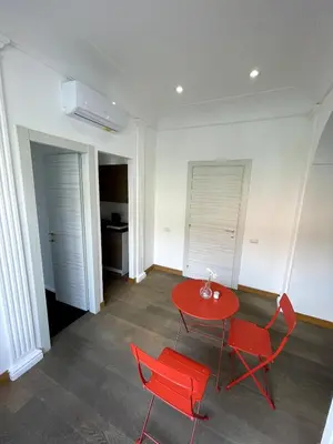 a room with a red table and two red chairs at Giulia Mesa Suites in Rome