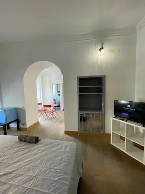a bedroom with a bed and a flat screen tv at Giulia Mesa Suites in Rome