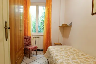 a bedroom with a bed and a window and a chair at Appartamento a Roma a due passi da Trastevere in Rome