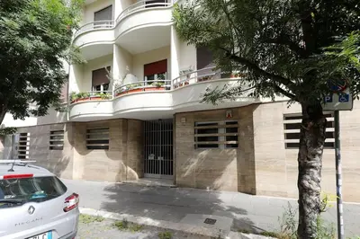 a white car parked in front of a building at The Brick Apartment by Nosdom Properties in Rome