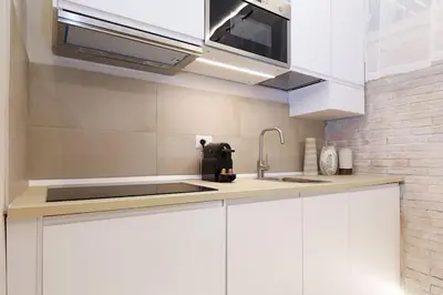 a kitchen with white cabinets and a sink at The Brick Apartment by Nosdom Properties in Rome