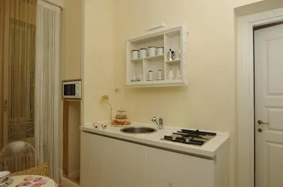 a white kitchen with a sink and a cabinet at Elegant Flat Spanish steps in Rome