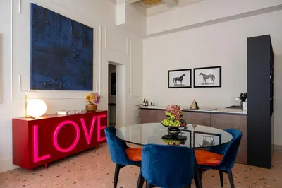 a dining room with a glass table and blue chairs at Elizabeth Unique Apartments - a Member of Design Hotels in Rome