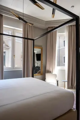 a bedroom with a large white bed and windows at Elizabeth Unique Apartments - a Member of Design Hotels in Rome
