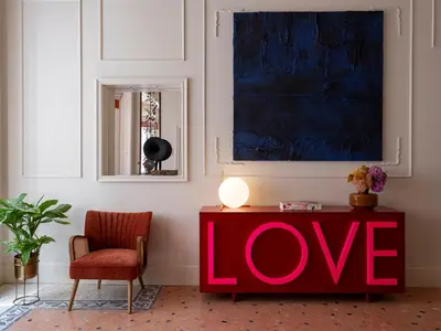 a living room with a red love sign on a table at Elizabeth Unique Apartments - a Member of Design Hotels in Rome