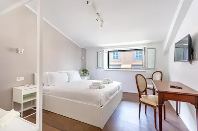 a white bedroom with a bed and a desk and a table at iFlat Bright Brand New 2-Bedroom Apt in Monti in Rome