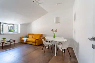 a living room with a table and a yellow couch at iFlat Bright Brand New 2-Bedroom Apt in Monti in Rome