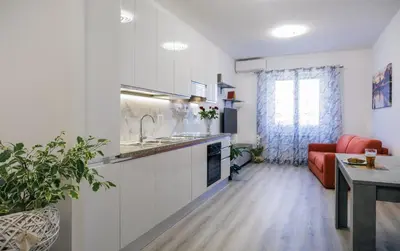 a kitchen and living room with a red couch at Le tue vacanze a Roma-2 bagni-nuovo apt in Rome