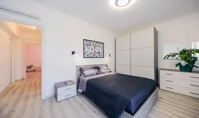 a bedroom with a bed and a dresser with a plant at Le tue vacanze a Roma-2 bagni-nuovo apt in Rome