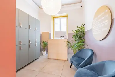 a waiting room with a blue chair and a mirror at Hotel Infinito - Gruppo BLAM HOTELS in Rome