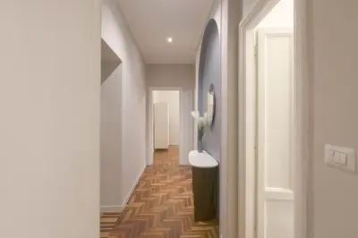a hallway with a white hallway with a vase at Piramide Deluxe Apartment in Rome