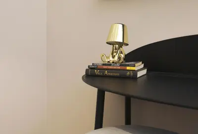 a lamp sitting on top of a table with books at Piramide Deluxe Apartment in Rome