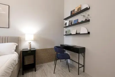 a bedroom with a desk with a blue chair and a bed at Piramide Deluxe Apartment in Rome