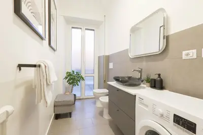 a bathroom with a sink and a washing machine at Piramide Deluxe Apartment in Rome