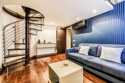 a living room with a couch and a spiral staircase at Home at Rome Luxury Navona Suites in Rome