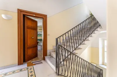 a staircase in a house with a wooden door at iFlat Retro Style Apartment near the Vatican in Rome