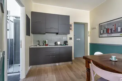 a kitchen with gray cabinets and a wooden table at iFlat Retro Style Apartment near the Vatican in Rome