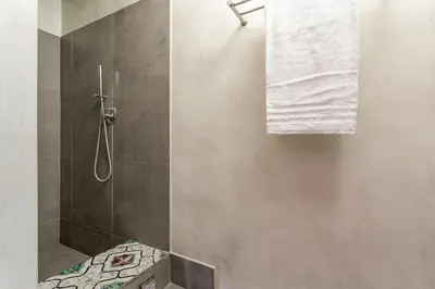 a bathroom with a shower with a towel on the wall at iFlat Baroque Apartment in Campo de' Fiori in Rome