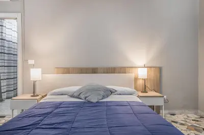 a bedroom with a large blue bed with two lamps at House Grimaldi in Rome
