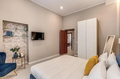 a bedroom with a white bed and a blue chair at Pretorius Charming New Apt in Rome