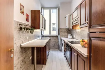 a small kitchen with wooden cabinets and a window at Pretorius Charming New Apt in Rome