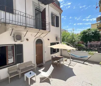 a house with a patio with a table and a hammock at Urban Retreat in Rome