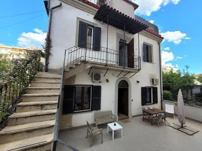 a white house with stairs and a table and chairs at Urban Retreat in Rome