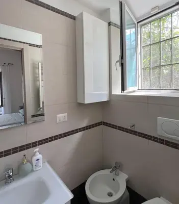 a bathroom with a sink and a toilet and a window at Urban Retreat in Rome
