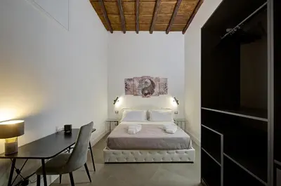 a bedroom with a bed and a table and a desk at Domus Capitolina Campo De' Fiori in Rome
