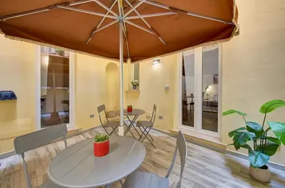a table and chairs with an umbrella in a room at Domus Capitolina Campo De' Fiori in Rome