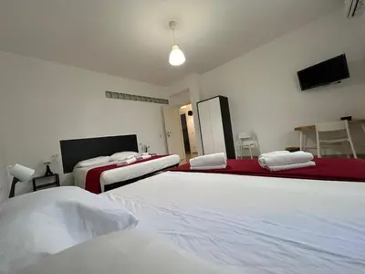 a bedroom with three beds with white sheets at Peppe's Bed in Rome