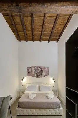 a bedroom with a large bed with a wooden ceiling at Domus Capitolina Navona in Rome