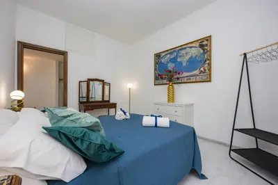 a bedroom with a bed with a blue blanket at Apartment Metro San Paolo -Air Conditioning-WIFI-TV55