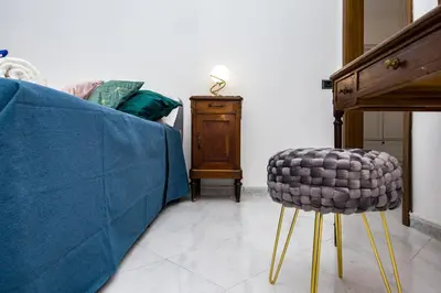a living room with a couch and a stool at Apartment Metro San Paolo -Air Conditioning-WIFI-TV55